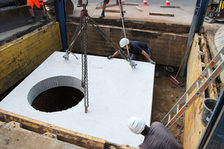 Das Bild zeigt, wie Bauarbeiter die Betonplatte installieren