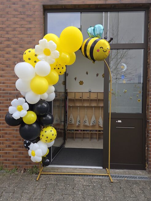 Porta d'ingresso, incorniciata da palloncini bianchi, gialli e neri.