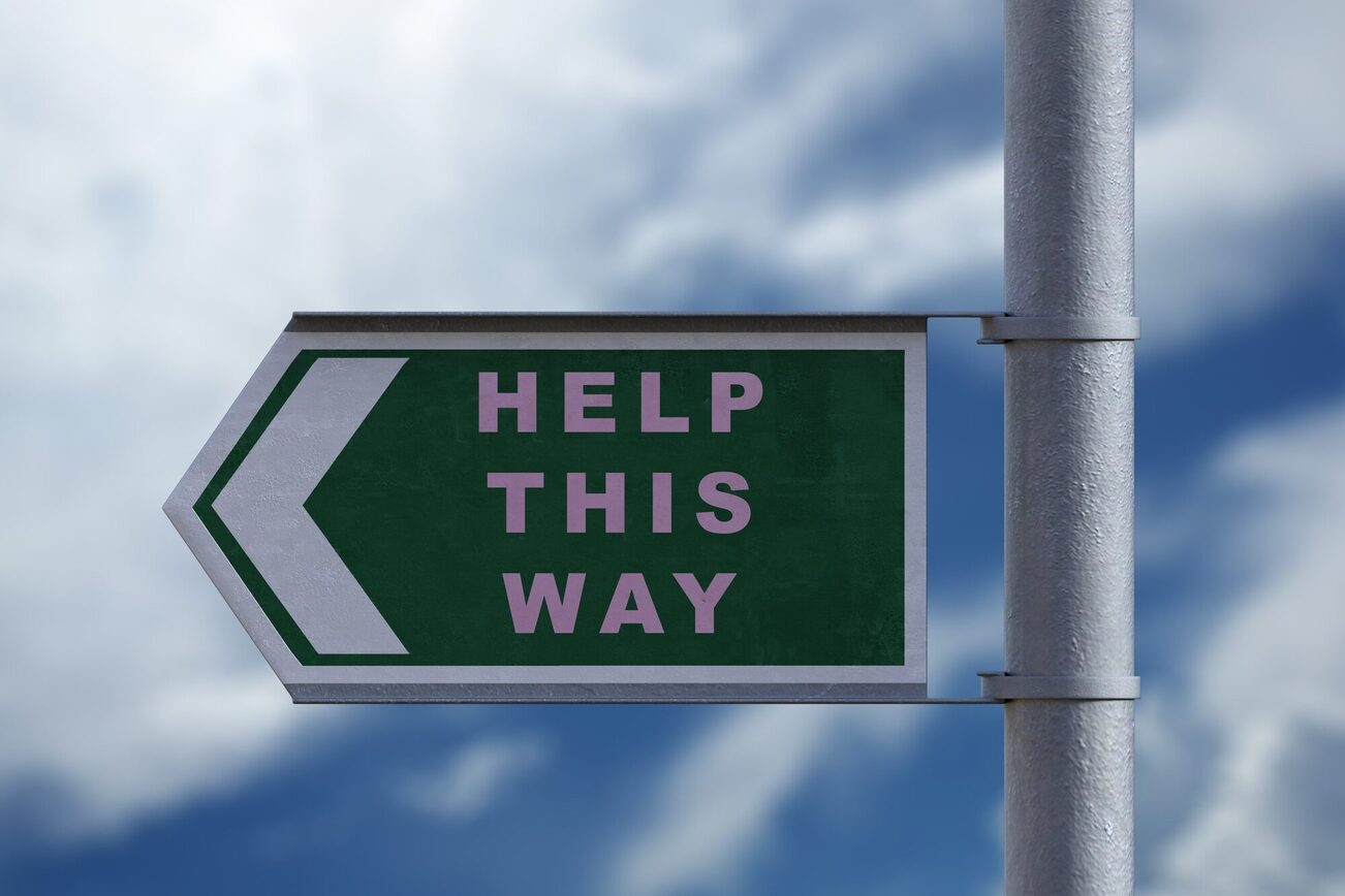 Ein Schild mit der Aufschrift Help this way