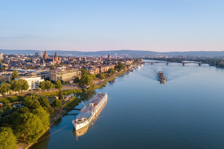 An aerial view of the city of Mainz shortly before sunset. On the left side of the picture, you can see the buildings of Mainz, and on the right, the Rhine.