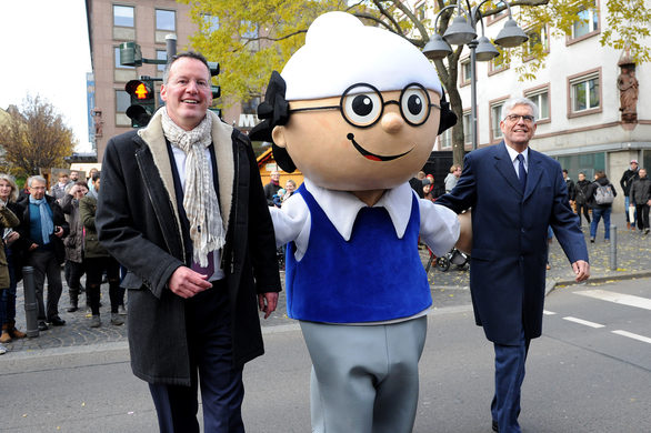 Oberbürgermeister Michael Ebling und ZDF-Intendant Dr. Thomas Bellut schreiten mit Mainzelmännchen Det über den ersten Mainzelmännchen-Fußgängerüberweg Deutschlands.