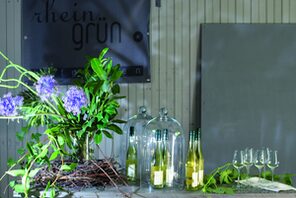 Tisch mit Wein, Blumendekoration vor Rheingrün Logo © Rheingrün Westhofen