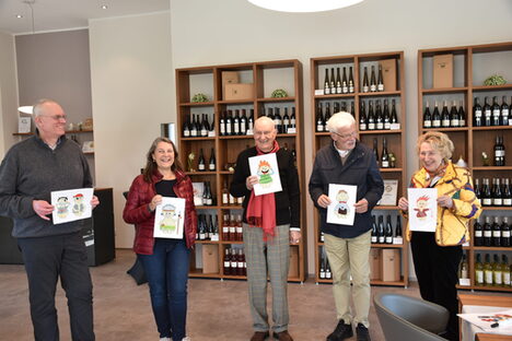 Fünf Menschen mit Karikaturen in Vinothek des Weingutes Paulinenhof