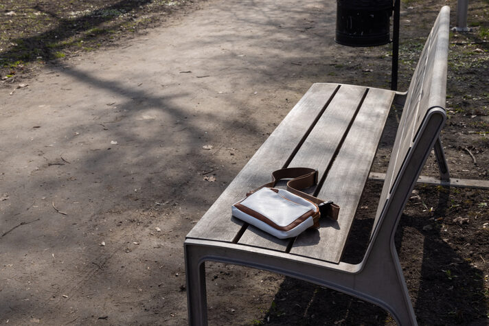Kleine Tasche liegt auf Parkbank